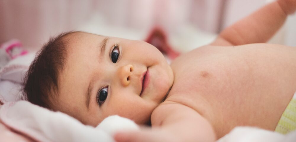 Ein süsses Baby lächelt in die Kamera